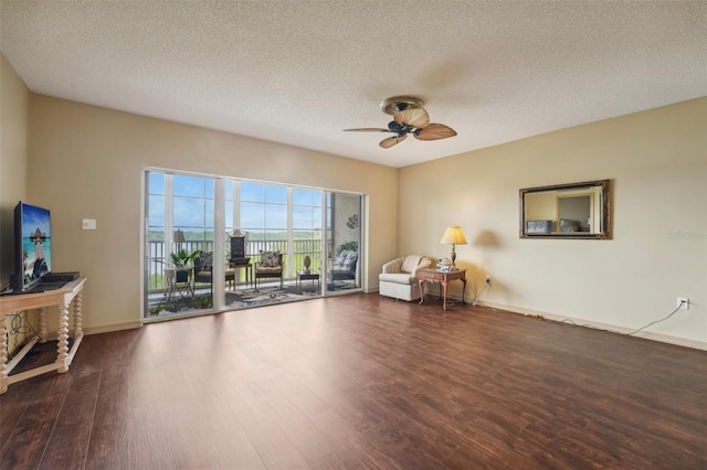 sitting room featuring ceiling fan, dark hardwood / wood-style floors, and a textured ceiling