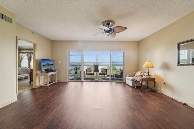 interior space featuring a wealth of natural light, ceiling fan, and dark hardwood / wood-style flooring