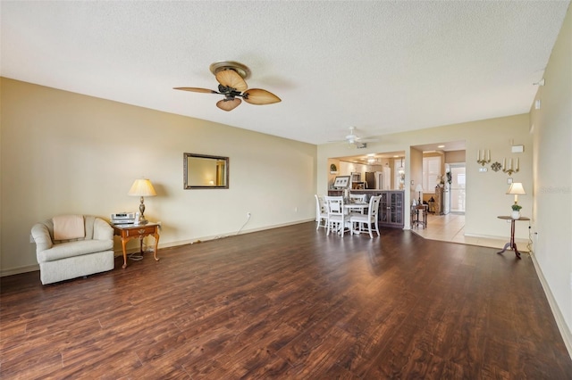 unfurnished living room featuring a textured ceiling, ceiling fan, and dark hardwood / wood-style floors