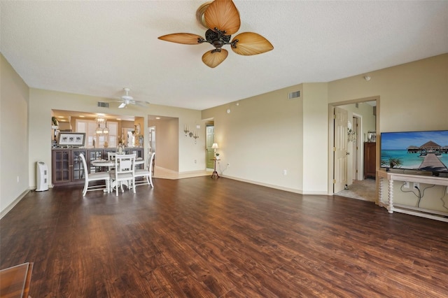 unfurnished living room with a textured ceiling, dark hardwood / wood-style flooring, and ceiling fan