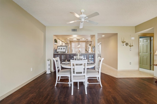 dining space with hardwood / wood-style floors, a textured ceiling, and ceiling fan