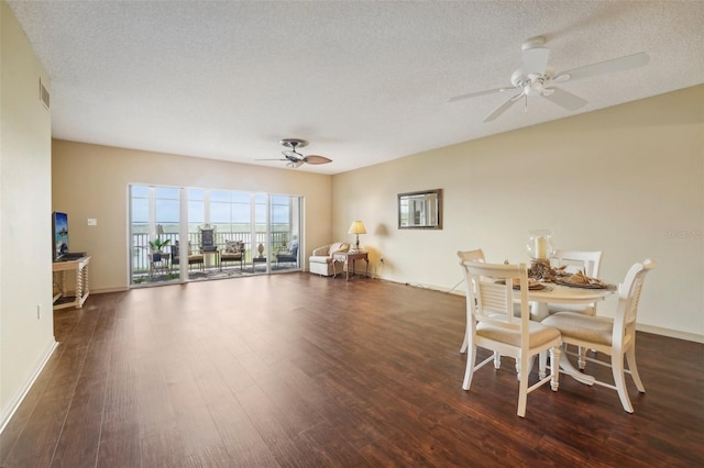 dining room with ceiling fan, dark hardwood / wood-style flooring, and a textured ceiling