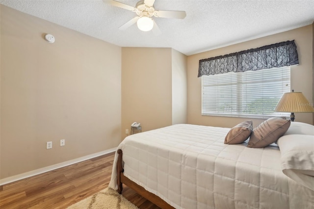 bedroom featuring a textured ceiling, hardwood / wood-style flooring, and ceiling fan