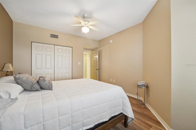 bedroom with ceiling fan, a closet, and hardwood / wood-style floors