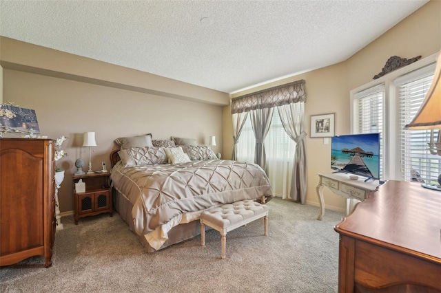 bedroom featuring a textured ceiling and light colored carpet