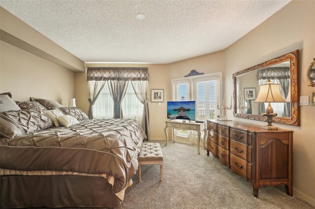 bedroom with light colored carpet and a textured ceiling