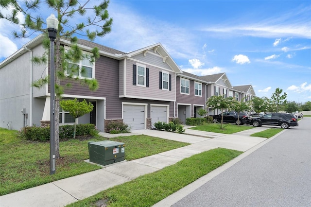 townhome / multi-family property with a garage and a front yard