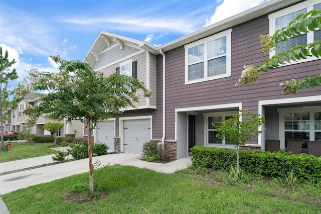 townhome / multi-family property featuring a garage and a front yard