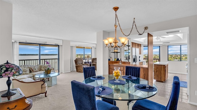 carpeted dining area featuring a chandelier, a textured ceiling, and sink