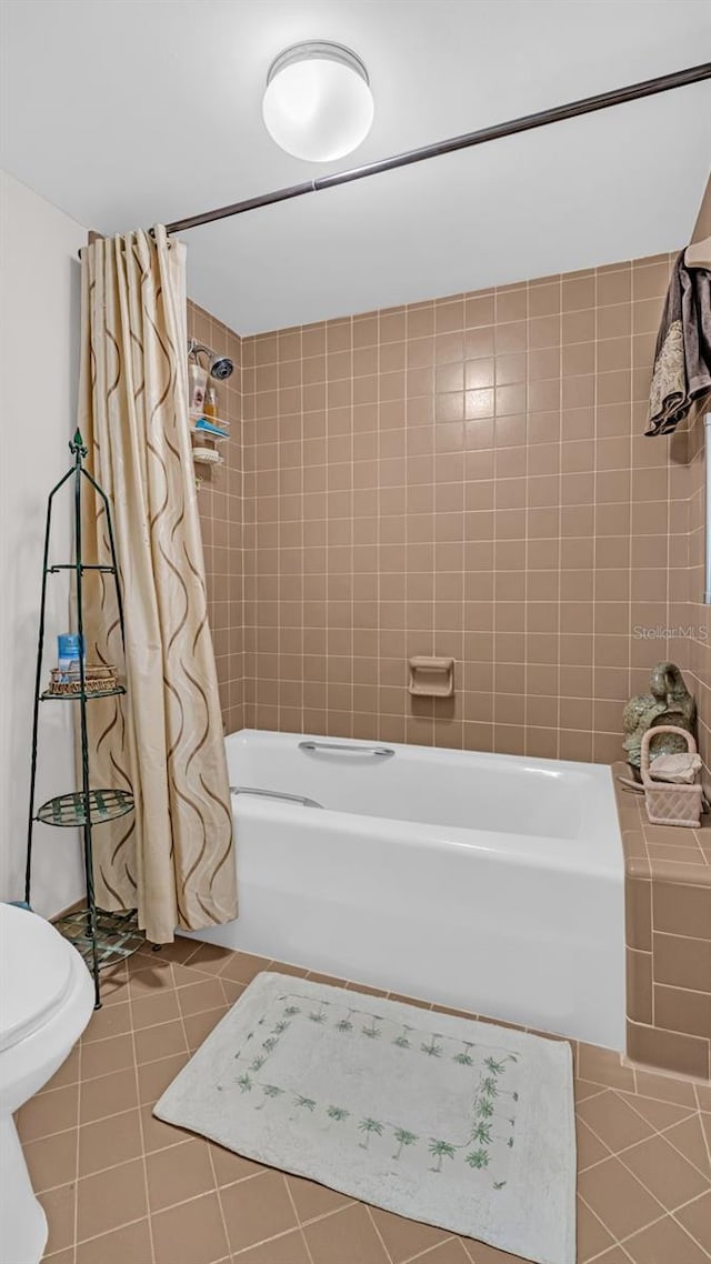 bathroom with tile patterned flooring, shower / tub combo, and toilet