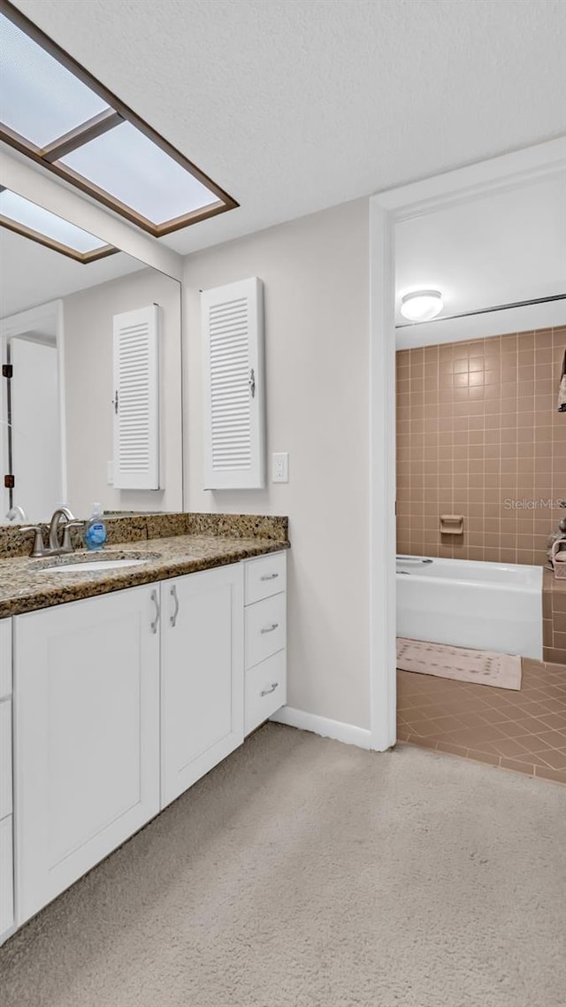 bathroom with vanity and tiled shower / bath combo