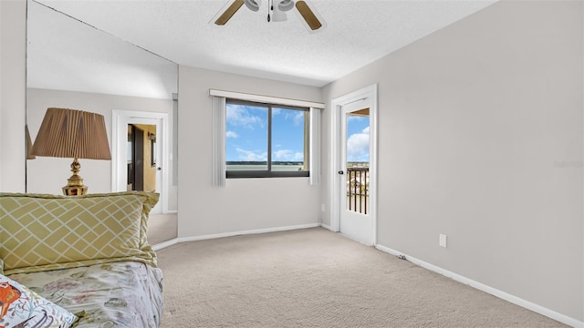 sitting room with a textured ceiling, ceiling fan, and light carpet