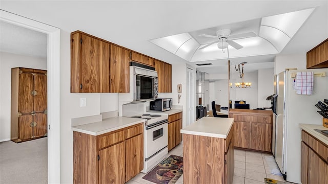 kitchen featuring ceiling fan with notable chandelier, a kitchen island, pendant lighting, white range with electric cooktop, and light tile patterned flooring