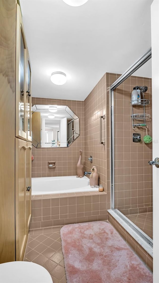 bathroom featuring tile patterned floors, toilet, and plus walk in shower