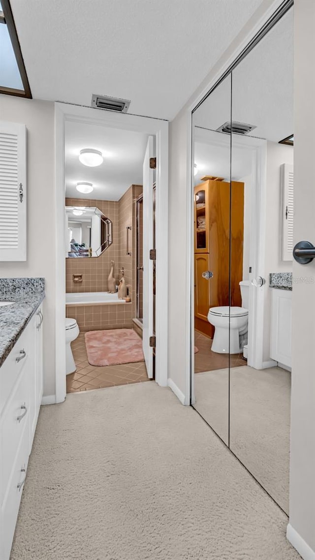 full bathroom with vanity, separate shower and tub, and toilet