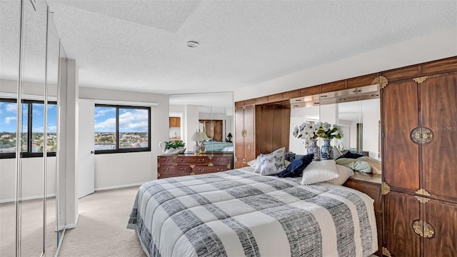 bedroom with light colored carpet and a textured ceiling