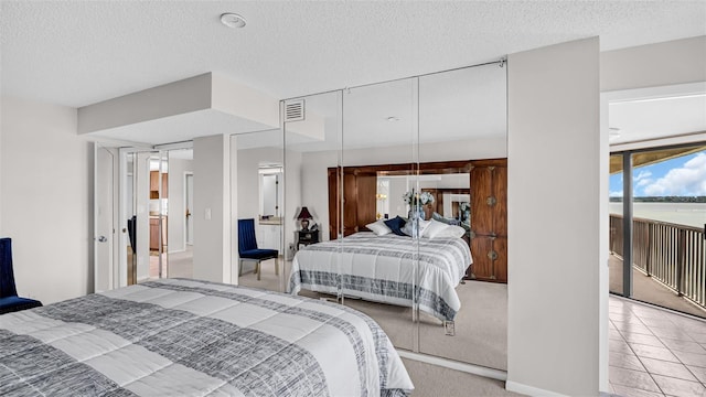 bedroom featuring light carpet and a textured ceiling