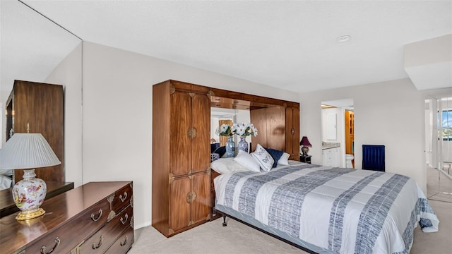 bedroom featuring light colored carpet and connected bathroom