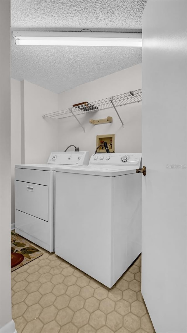 washroom with separate washer and dryer and a textured ceiling