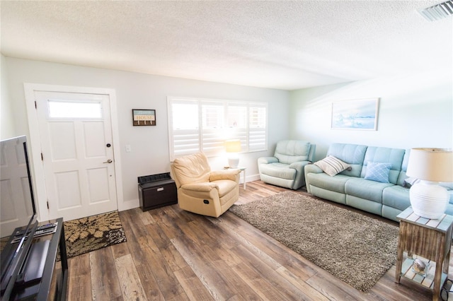 living room with dark hardwood / wood-style flooring and a textured ceiling