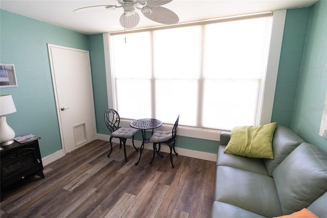 sitting room with a ceiling fan, baseboards, visible vents, and wood finished floors