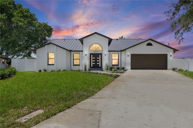 view of front of house with a garage and a lawn