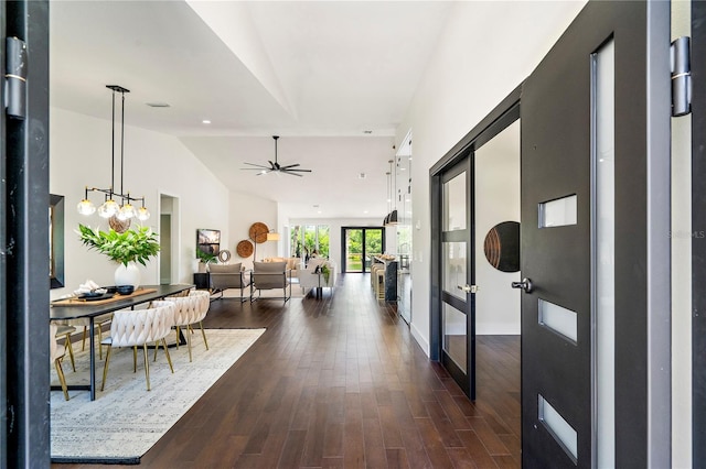 corridor with dark hardwood / wood-style flooring and vaulted ceiling