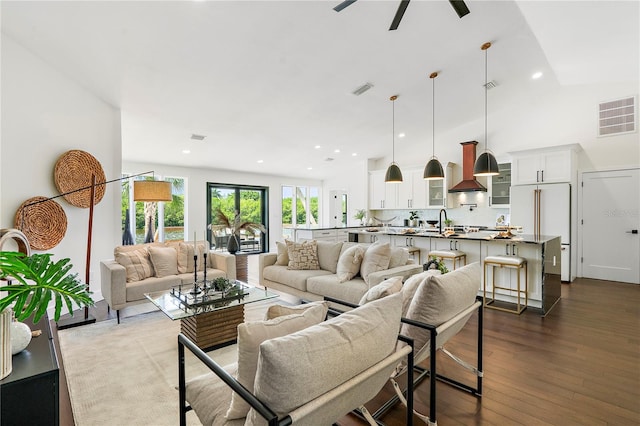 living room featuring sink, vaulted ceiling, and dark hardwood / wood-style floors