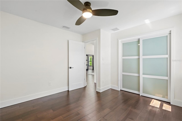 unfurnished room featuring dark wood-type flooring and ceiling fan