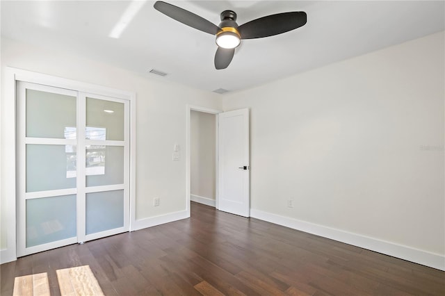 unfurnished room featuring dark wood-type flooring and ceiling fan