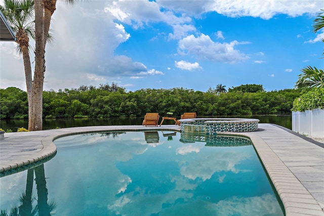 view of swimming pool with an in ground hot tub and a water view