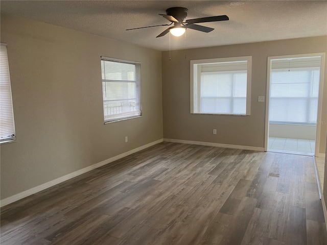 unfurnished room with a textured ceiling, ceiling fan, and dark wood-type flooring