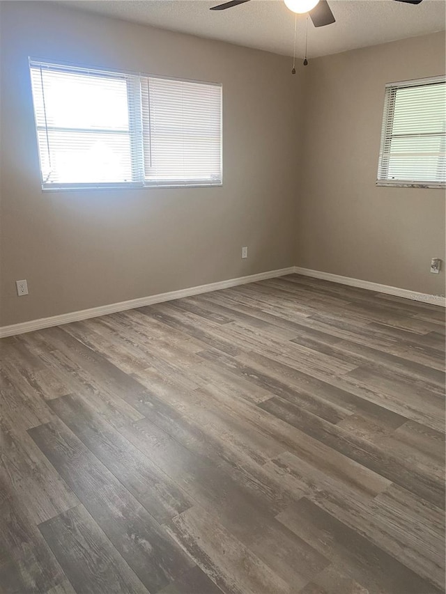 spare room featuring a textured ceiling, ceiling fan, and dark hardwood / wood-style floors