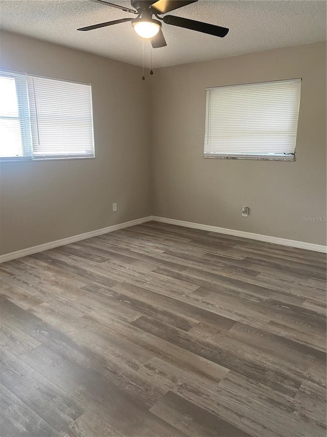 empty room with ceiling fan, wood-type flooring, and a textured ceiling