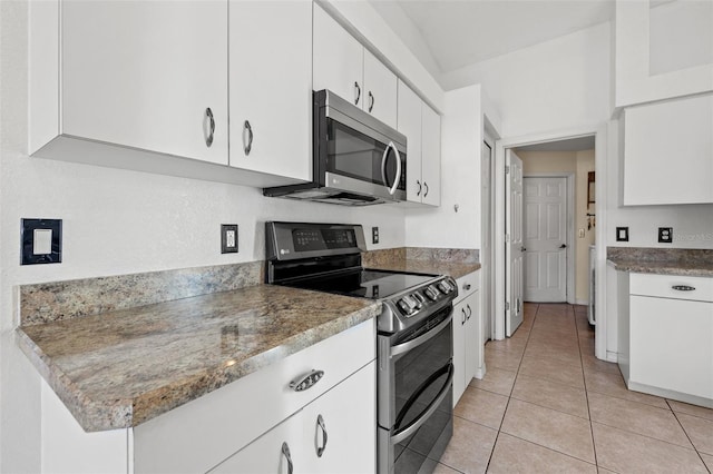 kitchen featuring black electric range, white cabinets, and light tile patterned flooring