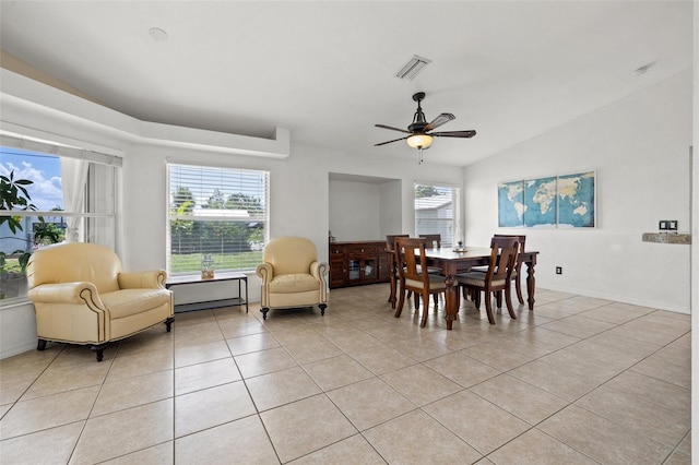 dining space with ceiling fan, light tile patterned flooring, and vaulted ceiling