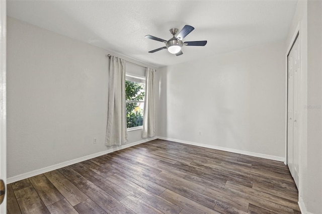 unfurnished room featuring ceiling fan and dark hardwood / wood-style flooring