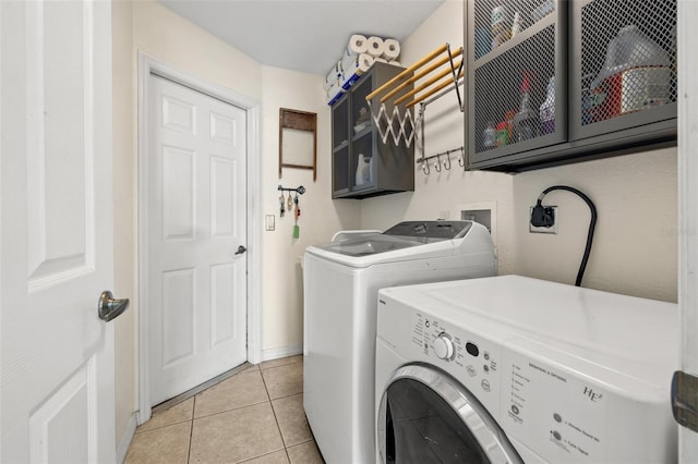 laundry room with cabinets, separate washer and dryer, and light tile patterned flooring