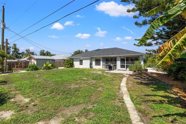 back of property featuring a yard and a sunroom