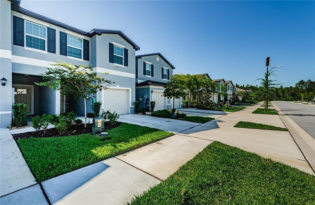 townhome / multi-family property with a front yard and a garage