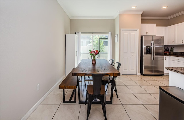 dining room with light tile patterned flooring and crown molding