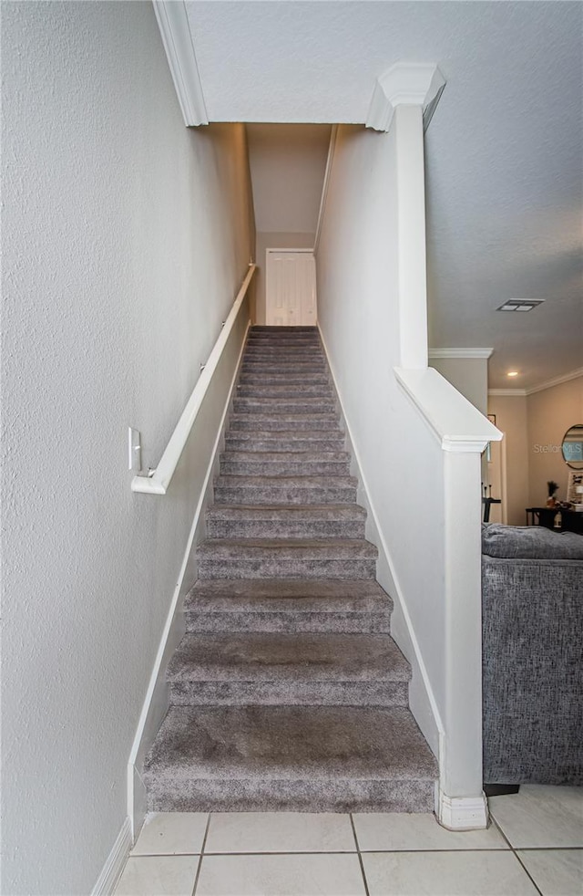 stairs with tile patterned flooring and ornamental molding