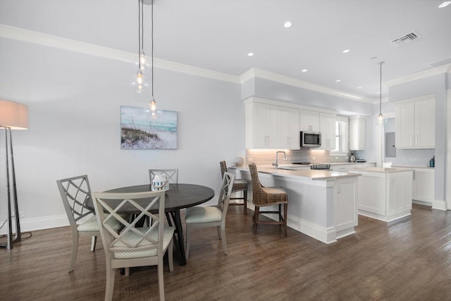 kitchen with white cabinets, backsplash, decorative light fixtures, and dark hardwood / wood-style flooring