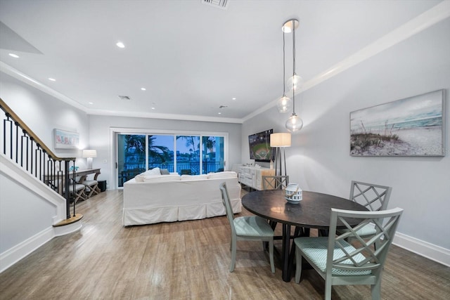 dining area featuring crown molding and hardwood / wood-style floors