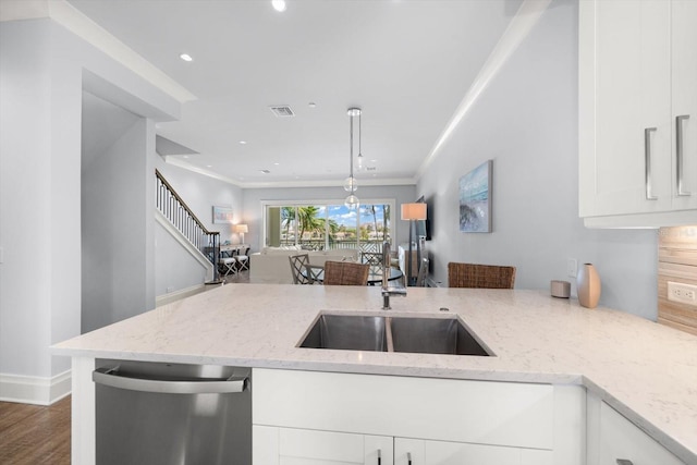 kitchen featuring light stone counters, white cabinetry, dishwasher, hardwood / wood-style flooring, and ornamental molding