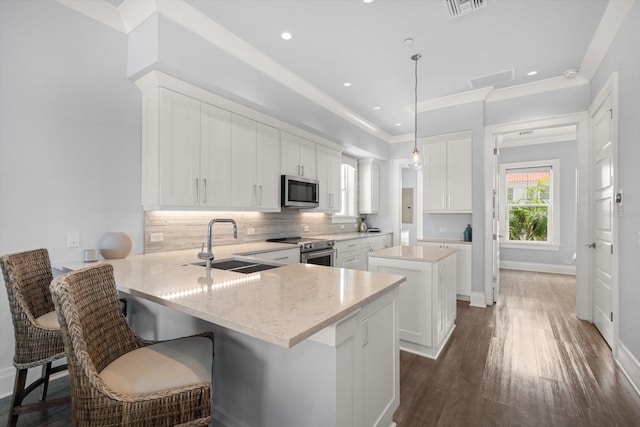 kitchen with a center island, backsplash, dark hardwood / wood-style flooring, stainless steel appliances, and decorative light fixtures