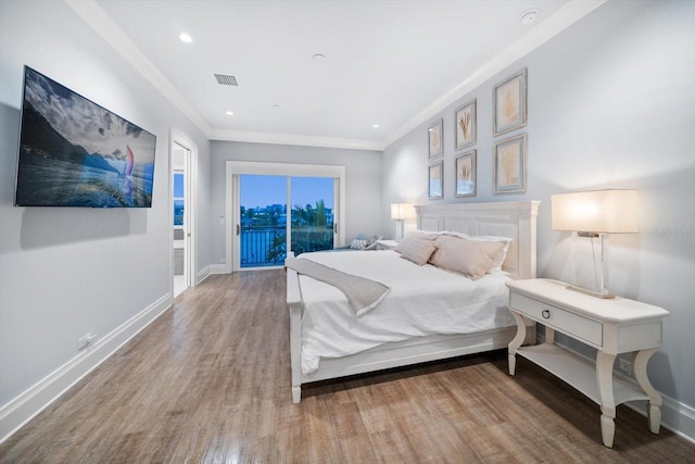 bedroom featuring crown molding, wood-type flooring, and access to outside