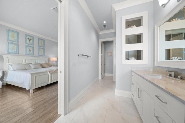 bathroom featuring ornamental molding, vanity, and wood-type flooring