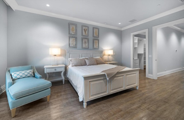 bedroom featuring dark hardwood / wood-style floors, crown molding, a closet, and a walk in closet