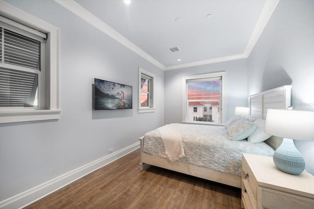 bedroom with crown molding and dark hardwood / wood-style floors